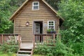 Cute log cabin in the woods in alaska. Porch in the front with the door open