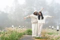 Cute long-haired Asian best friend wearing winter clothes standing happily smiling in the fog on a cold winter day in a tourist Royalty Free Stock Photo