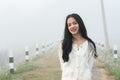 Cute long haired asian girl teen put on winter clothes standing happily smiling in the fog covered On a very cold Royalty Free Stock Photo