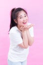 Cute lovely of beautiful young asian woman black hair wear a white t-shirt standing and sending kiss over pink background. Royalty Free Stock Photo