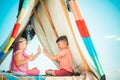 Cute lovely children play in tent. Kids playing with a teepee tent.