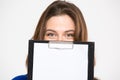 Cute lovely young woman hiding behind blank clipboard Royalty Free Stock Photo