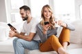 Cute loving couple indoors at home using mobile phones Royalty Free Stock Photo