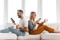 Cute loving couple indoors at home using mobile phones Royalty Free Stock Photo