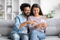 Cute loving indian couple using smartphone at home Royalty Free Stock Photo