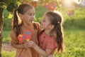 Cute loving sisters hold heart with puzzles supporting each other on autism Day