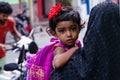 Cute maldivian girl on mother's hand looking back