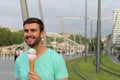 Cute male digging an ice cream outdoors