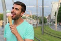 Cute male digging an ice cream outdoors