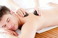 Cute man enjoying a back massage with hot stones Royalty Free Stock Photo