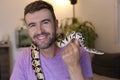 Cute man holding exotic ball python Royalty Free Stock Photo