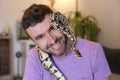 Cute man holding exotic ball python Royalty Free Stock Photo