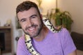 Cute man holding exotic ball python Royalty Free Stock Photo
