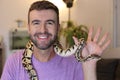 Cute man holding exotic ball python Royalty Free Stock Photo