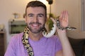 Cute man holding exotic ball python Royalty Free Stock Photo