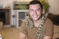 Cute man holding exotic ball python Royalty Free Stock Photo