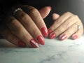 Cute manicure with red coating and rhinestones.