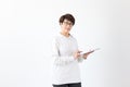 Cute middle-aged woman in casual clothes is looking online stores using a tablet on a white background. Concept of Royalty Free Stock Photo