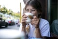 Cute pretty young woman drinks coffee milk foam Royalty Free Stock Photo