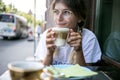 Cute pretty young woman drinks coffee milk foam Royalty Free Stock Photo