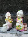 A cute mini statue of an old couple posing close up.