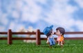 Cute Miniature dolls boy and girl sitting on the grass ground in the Farm with love and cute