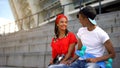 Cute mixed-race girl with skateboard sitting near guy, common interests, hobby Royalty Free Stock Photo