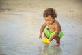 Cute mixed race little boy playing in the sand on a tropical beach vacation Royalty Free Stock Photo