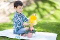 Cute Mixed Race Young Boy Waters a Potted Flowers Outsdoors Royalty Free Stock Photo