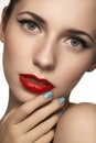 Cute model face with bright classical evening make-up, eyeliner on eyes, red lipstick