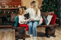 Cute mom and daughter are looking through a family photo album on Christmas Eve, spending time together by the fireplace Royalty Free Stock Photo