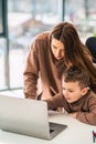 Cute mom and son doing homework at the laptop. Royalty Free Stock Photo