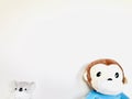 Cute monkey and Koala soft toy wearing a face mask with pale white background.