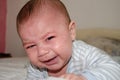 Cute 4 months old baby boy got tired of tummy time and starting to cry Royalty Free Stock Photo