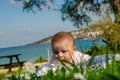 Cute 4 months old baby boy having a tummy time under the tree and sea in the background Royalty Free Stock Photo
