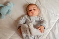 Cute 4 months old baby boy lying on bed and playing with his legs Royalty Free Stock Photo