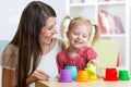 Cute mother and child daughter playing educational toys indoor