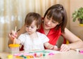 Cute mother teach her daughter kid to paint Royalty Free Stock Photo