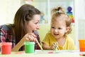 Cute mother teach her daughter kid to paint Royalty Free Stock Photo