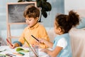 cute multiethnic children sitting and writing