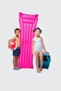 cute multiethnic kids with ball suitcase and swimming mattress looking at camera Royalty Free Stock Photo