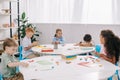 cute multiethnic preschoolers sculpturing figures with plasticine at tables