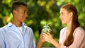 Cute multiethnic teenagers in love holding cocktail with two straws, romantic