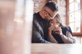 Cute multiracial couple sitting together in cafe. Asian girl with her caucasian boyfriend