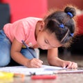 Cute multiracial small girl drawing on a coloring book