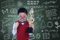 Cute nerd holding trophy in class Royalty Free Stock Photo