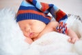 Cute newborn baby in blue knit cap sleeping in basket Royalty Free Stock Photo