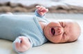 Cute newborn baby boy lying on bed, crying. Close up. Royalty Free Stock Photo