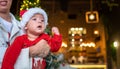 Cute newborn baby boy next to a Christmas tree with festive decoration and ferry lights for New Year celebration