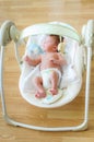 Cute newborn baby boy sitting in electrical swing Royalty Free Stock Photo